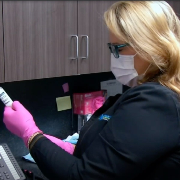 Staff member from Mountain State Oral and Facial Surgery on WCHS holding bottle of Exparel