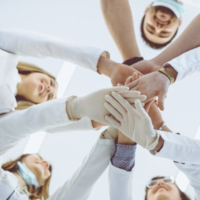A group of dentists gather for a gloved hand-stack