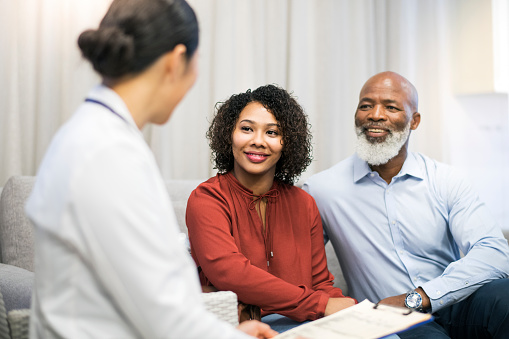 Older Black couple speaking with dentist at Mountain State Oral and Facial Surgery in Hurricane, WV