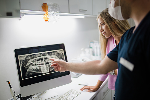 Dentist reviewing digital x-ray with assistant