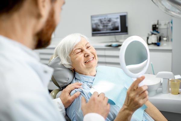 Elderly woman enjoying her implant supported dentures and new smile by Mountain State Oral and Facial Surgery in Charleston, WV