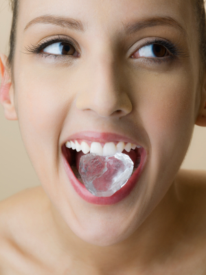 Woman biting down on an ice cube